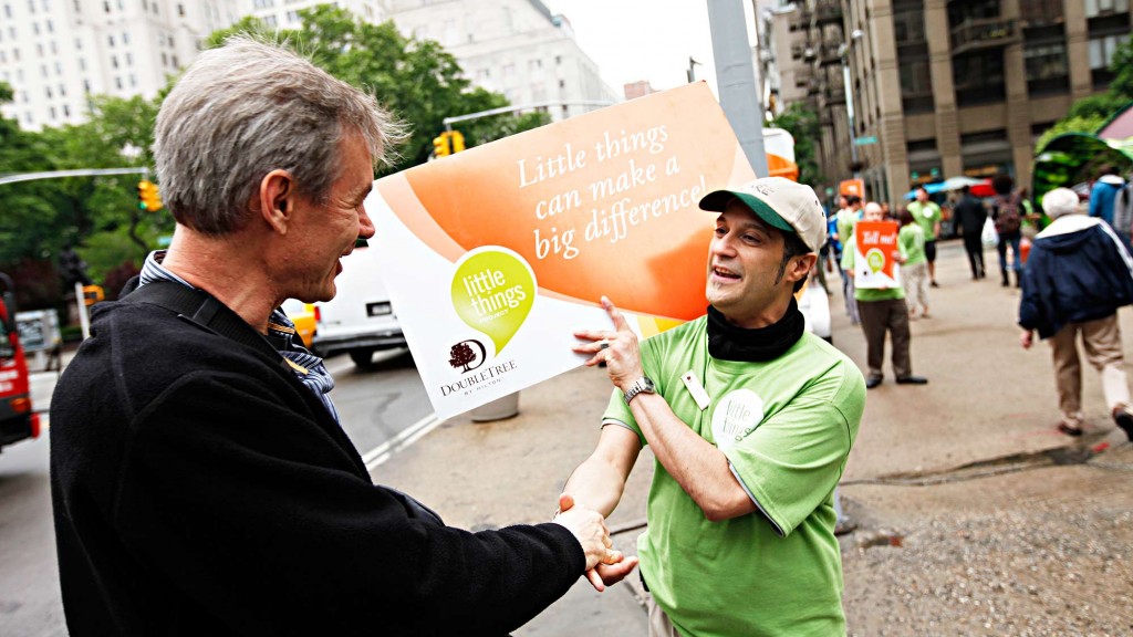 A man handing a man a sign.