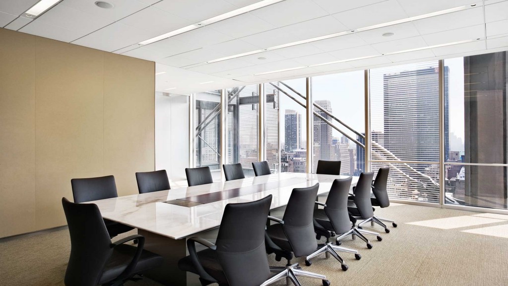 A conference room with a large table and chairs.