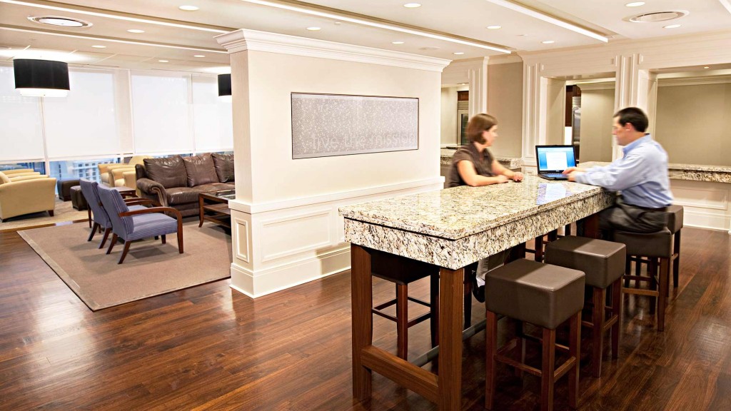 A man and woman sitting at a table with a laptop.