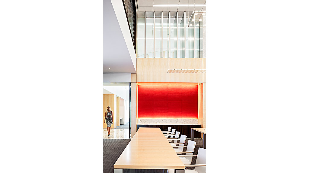 A person standing in a room with a large red board.
