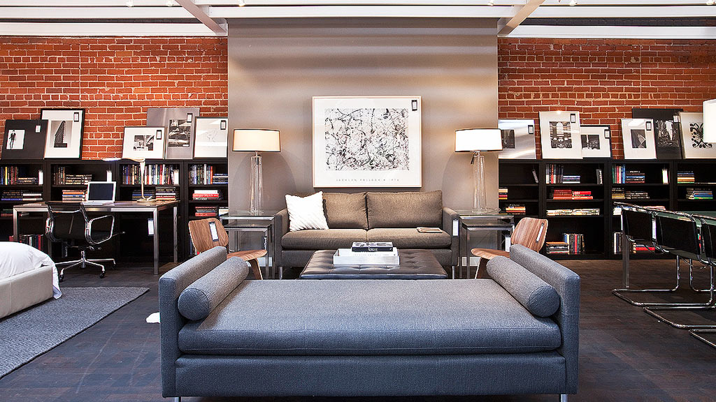 A living room with a couch and a desk.