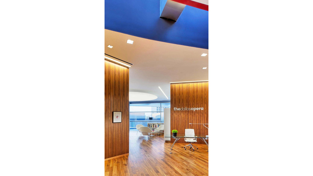 A room with a wood floor and a wood door with a view of the ocean.