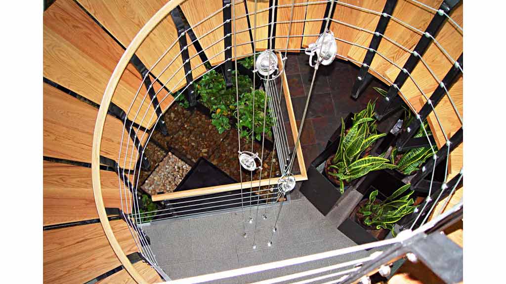 A spiral staircase with a planter.