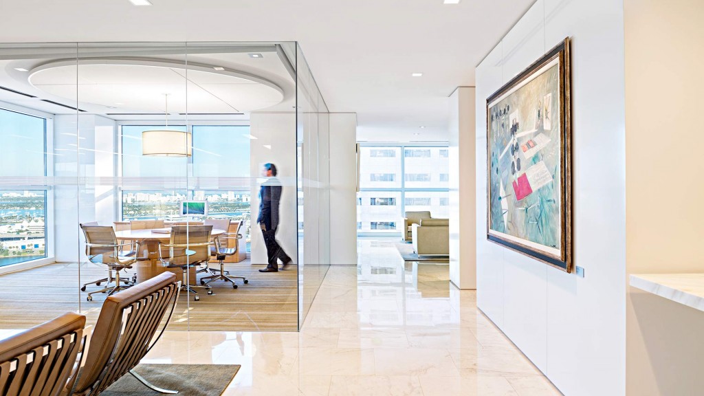 A person standing in a room with a large painting on the wall.
