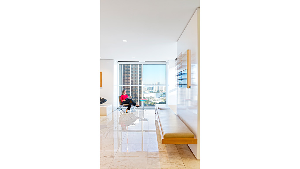 A person sitting on a chair in a room with a large window.