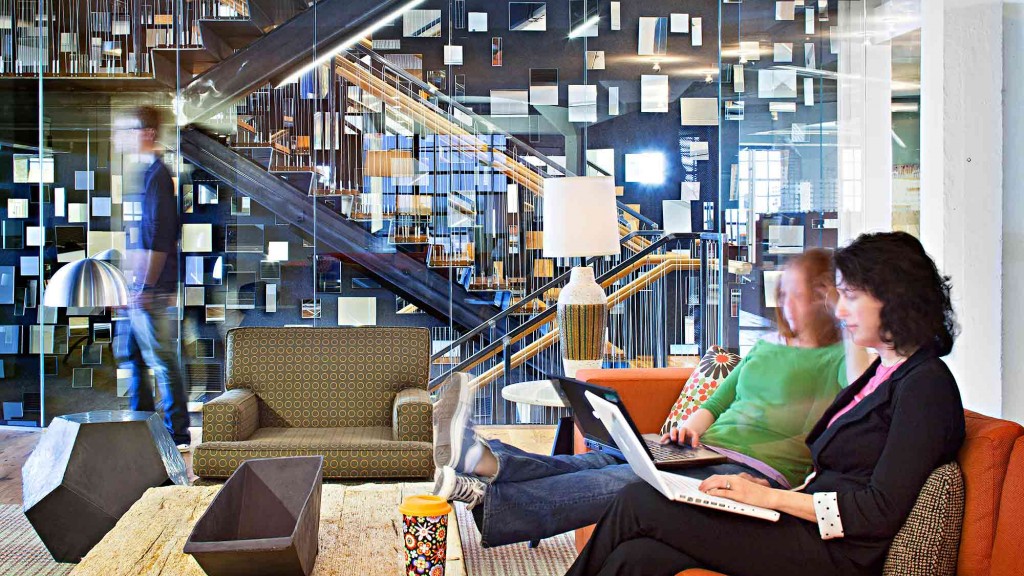 A man and woman sitting on a couch with a laptop.