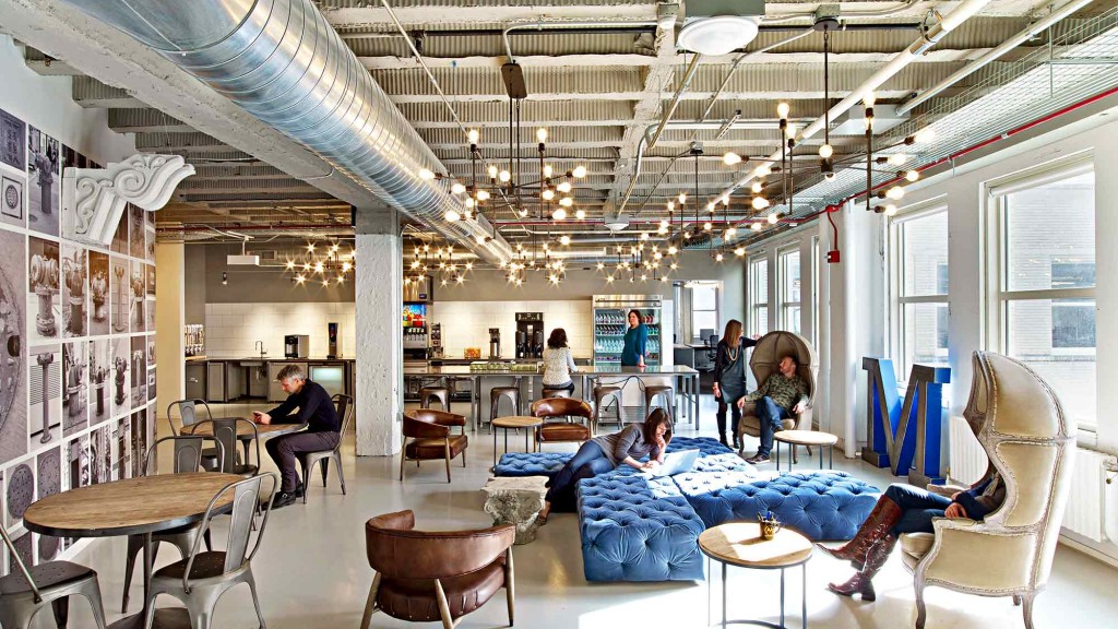 A group of people in a room with tables and chairs.