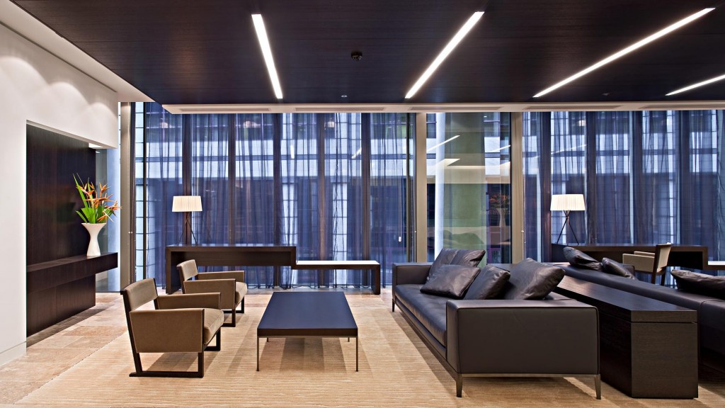 A room with a couch and a table with a plant on it.