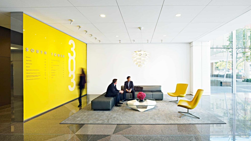 A few people sitting in a lobby.