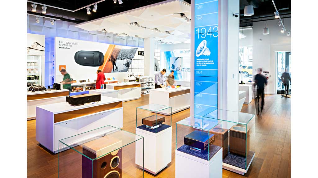 A room with several white tables and blue display.