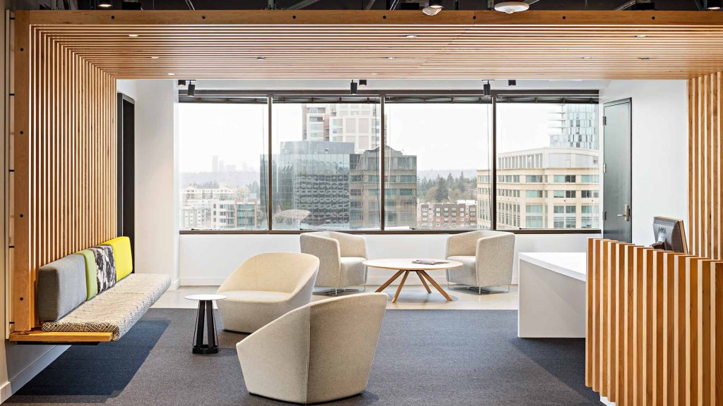 A room with a large window and a table with chairs and a view of a city.