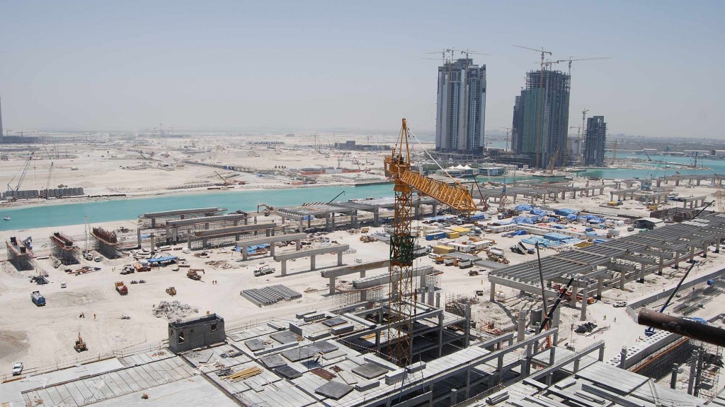 A large city with cranes and buildings.