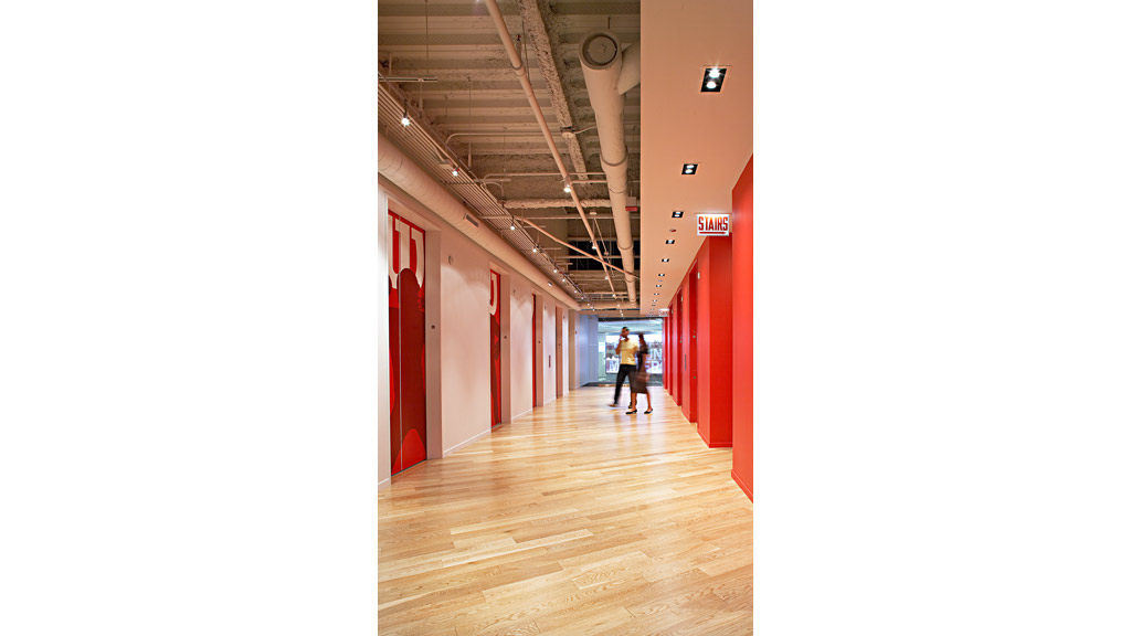 A couple of people walking down a hall way.