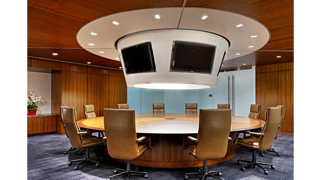 A conference room with a round table and chairs.