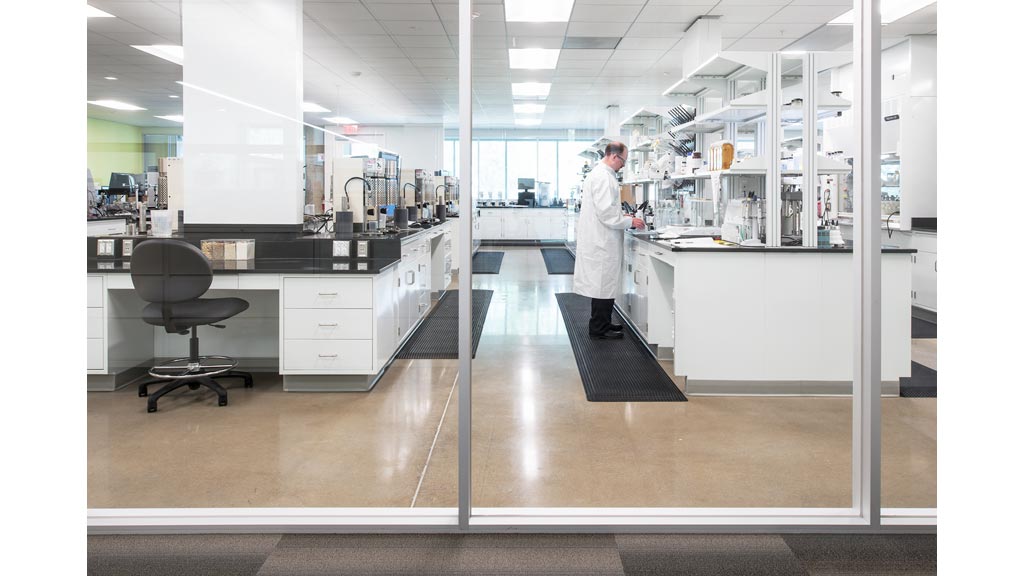 A person in a white coat in an office.