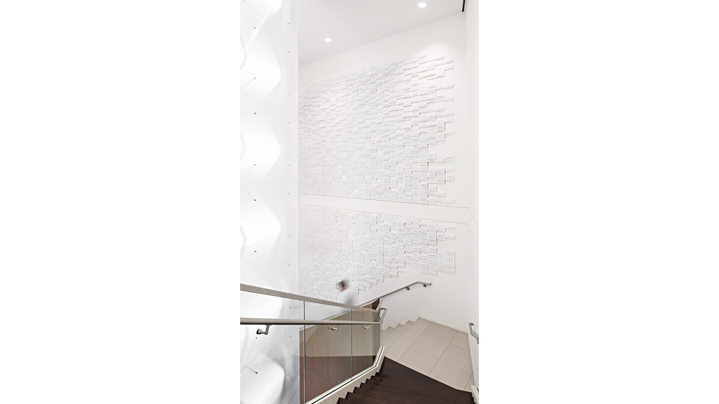 A staircase with a white wall.