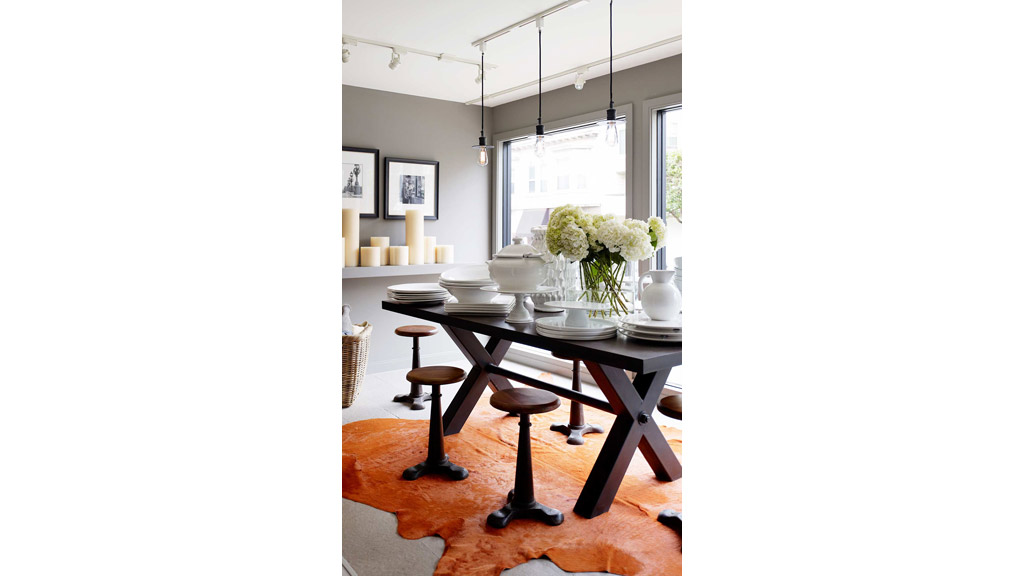 A dining table with a vase of flowers on it.