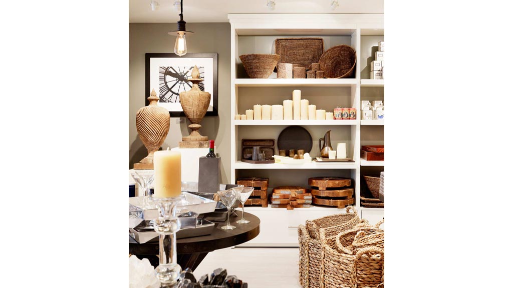 A room with a table and shelves with objects on it.