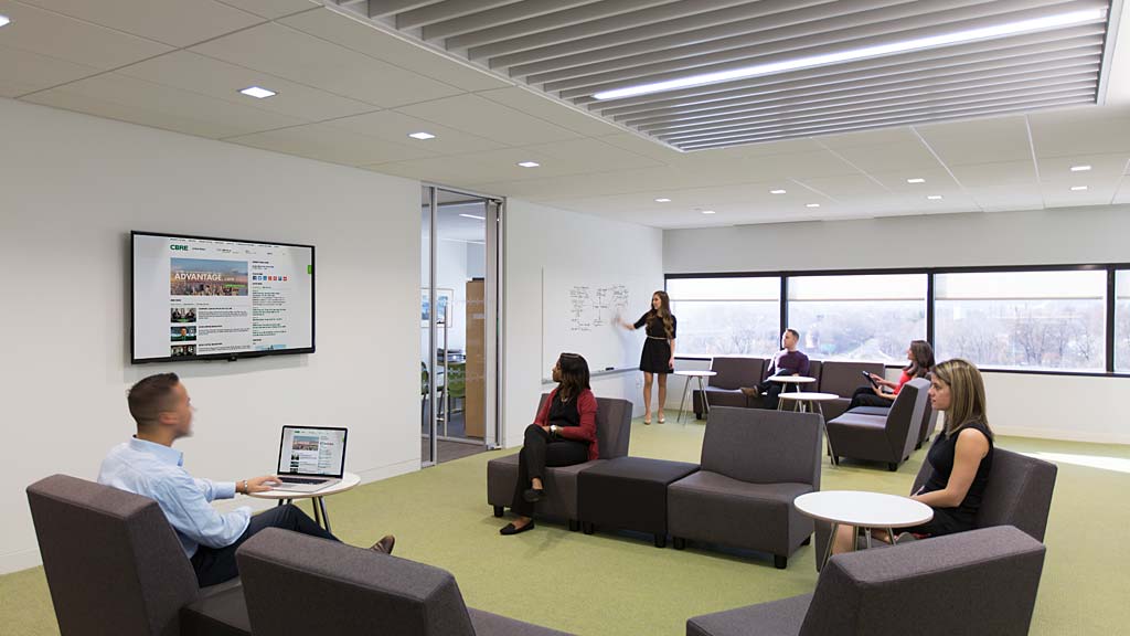 A group of people sitting in a room with a laptop.