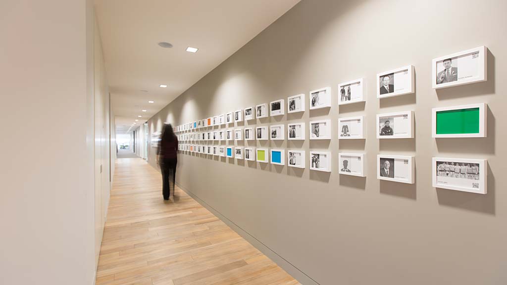 A person standing in a room with pictures on the wall.