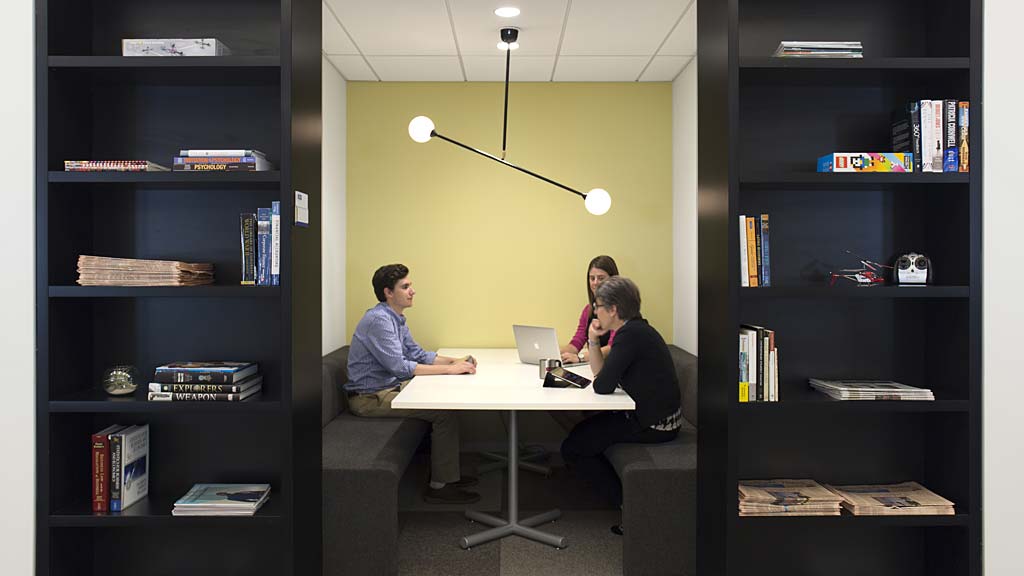 A man and a woman sitting at a table with a laptop.