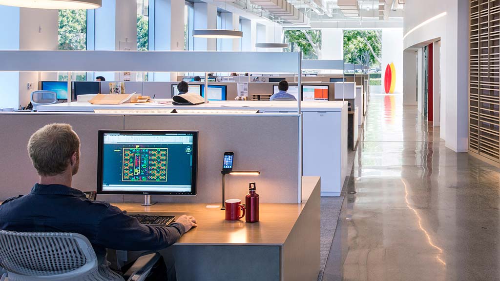 A man sitting at a desk with a computer in front of him.