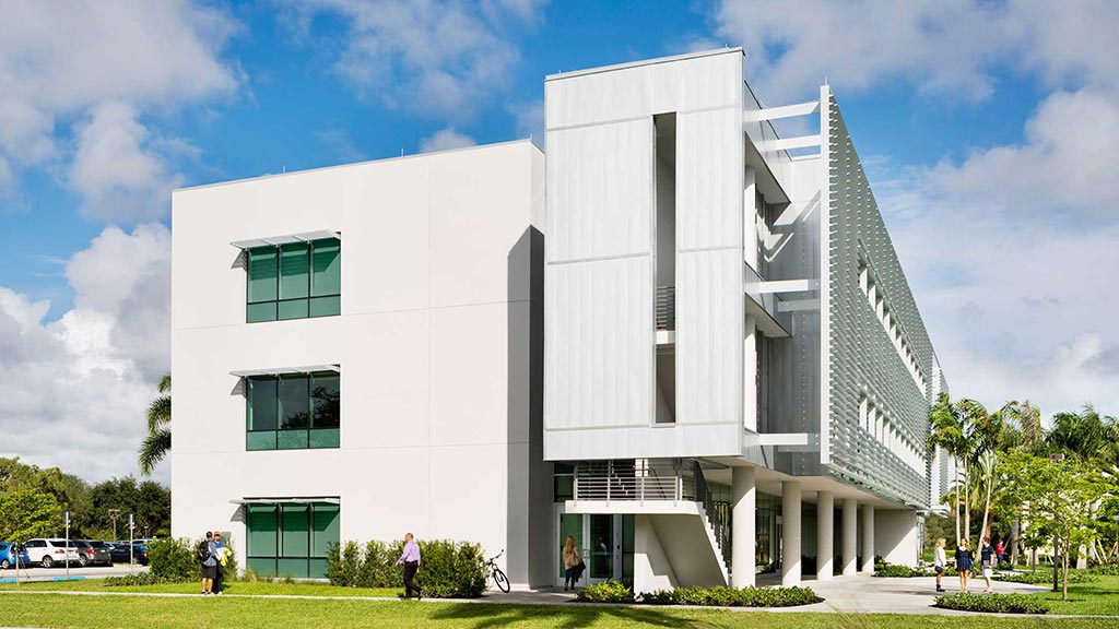 A white building with a green lawn.