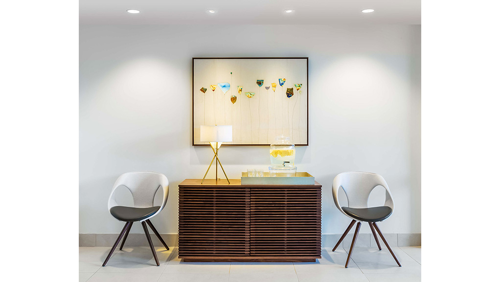 A room with chairs and a painting on the wall.