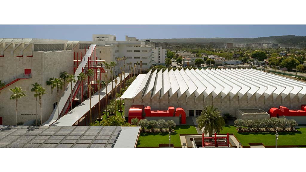 A large building with a courtyard with Los Angeles County Museum of Art in the background.