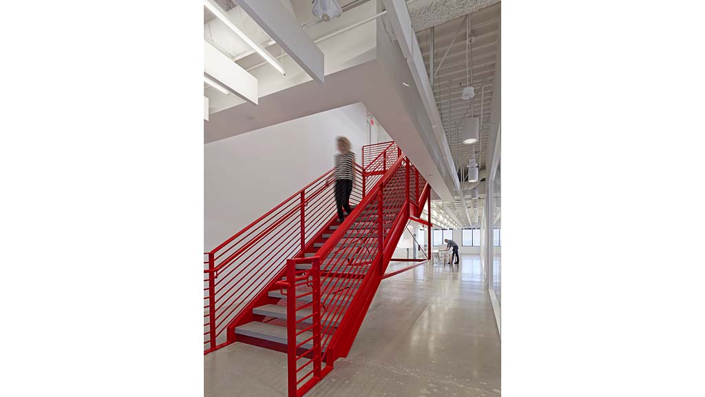 A person walking up a red staircase.