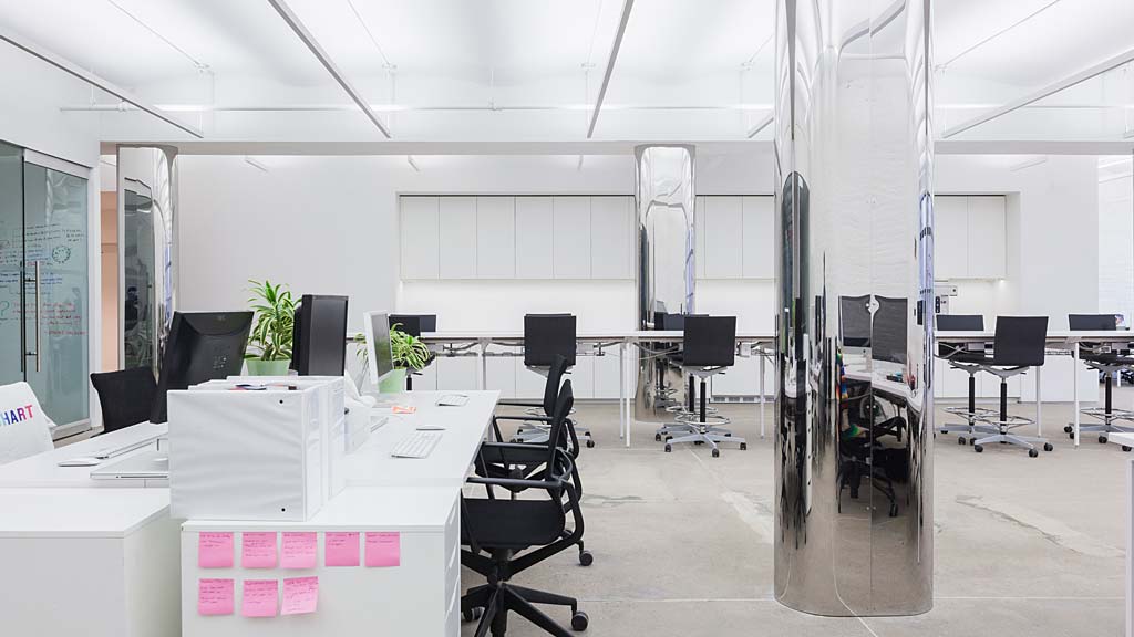 An office with white desks and chairs.