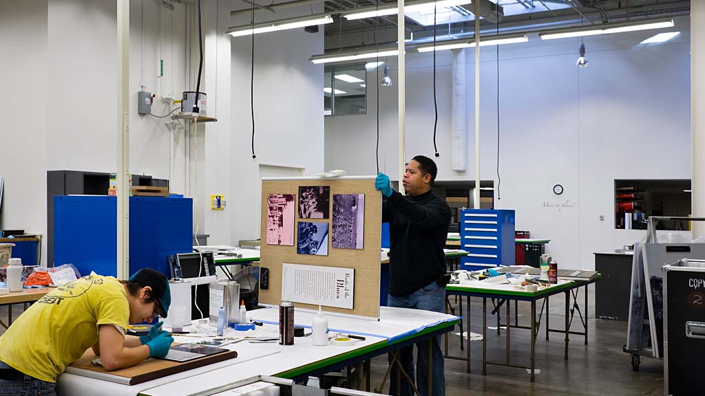 A person and a boy in a room with tables and chairs.