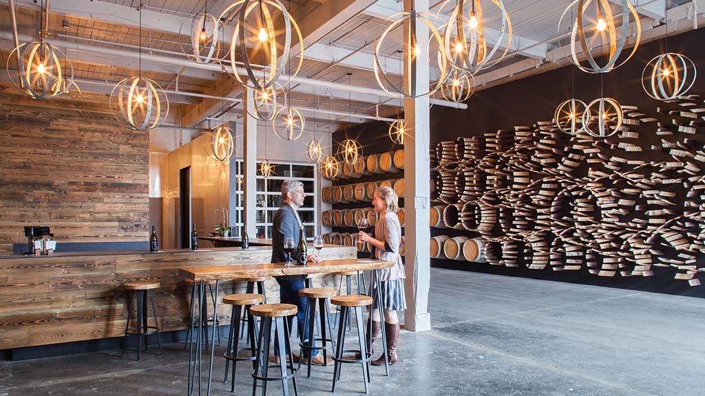 A couple of people standing in a room with a bar and lights.