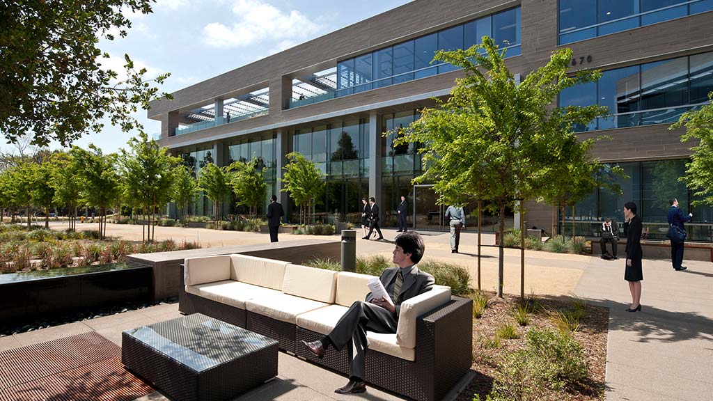 A person sitting on a bench outside a building.