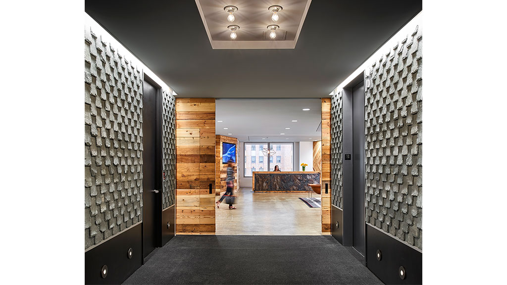 A hallway with a wood floor and a wood door.