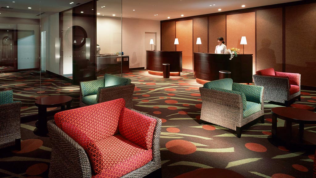 A room with a couch and chairs.