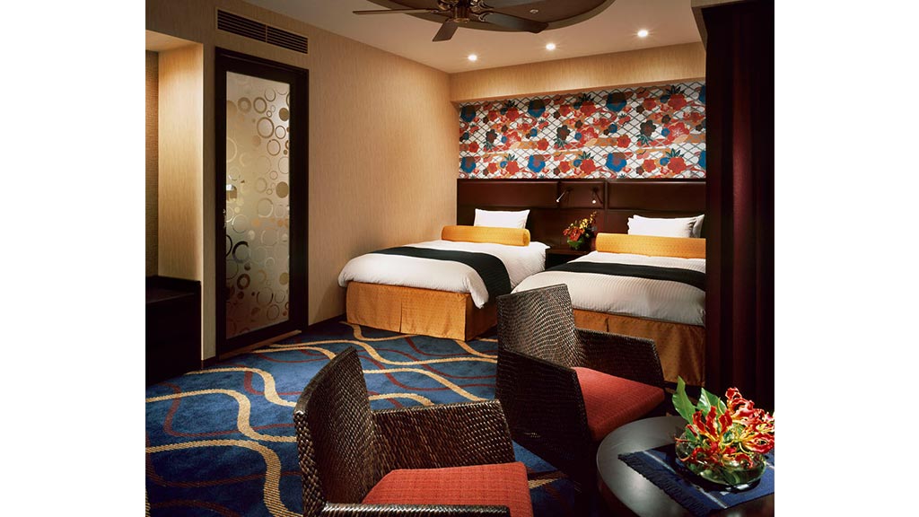 A bedroom with a large bed and a fan.