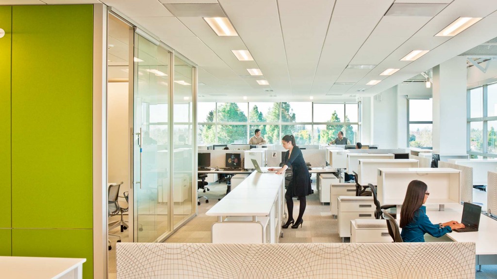 A person standing in front of a desk with a laptop.