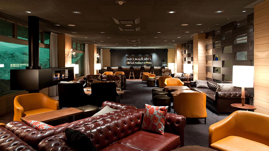 A room with a couch and chairs.