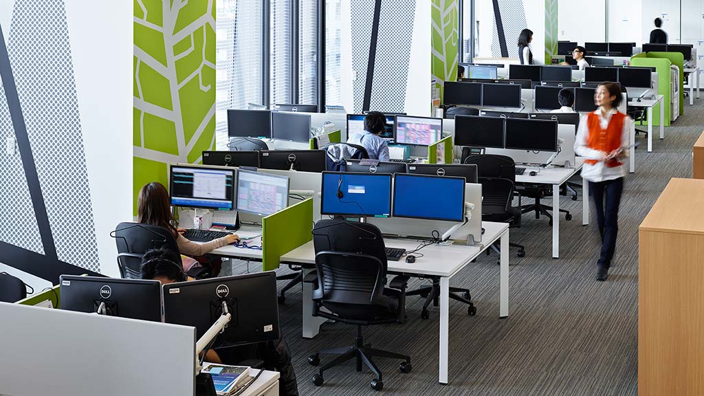 A person standing in front of a group of people sitting at computers.