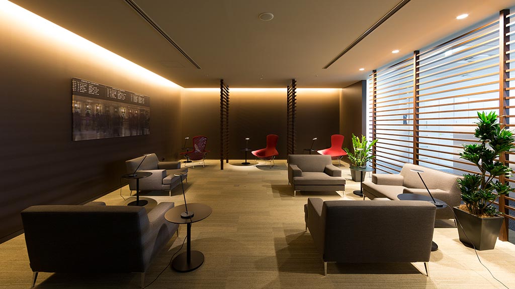 A room with a couch and chairs.