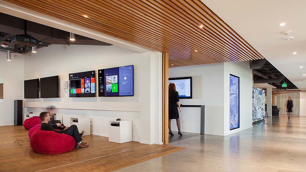 A group of people in a room with large screens.