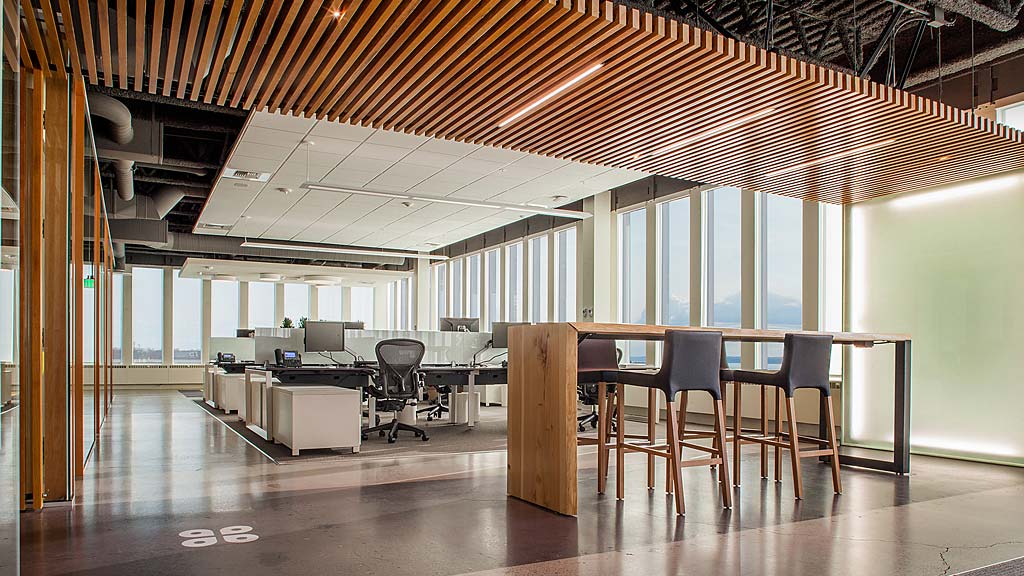 A room with a table chairs and a large window.