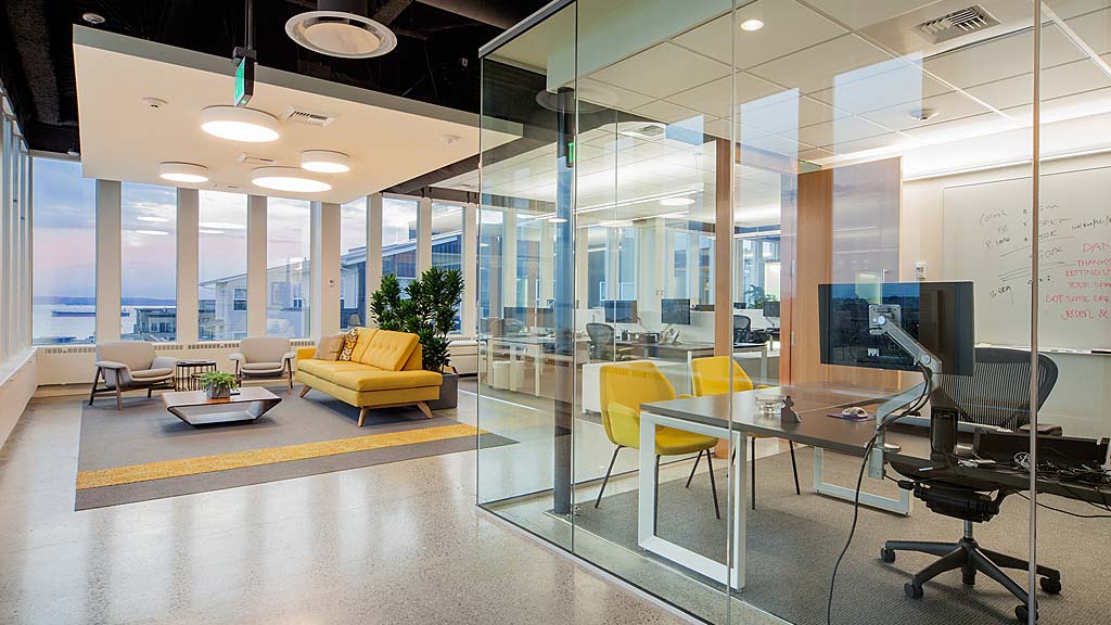 A room with a table chairs and a large window.