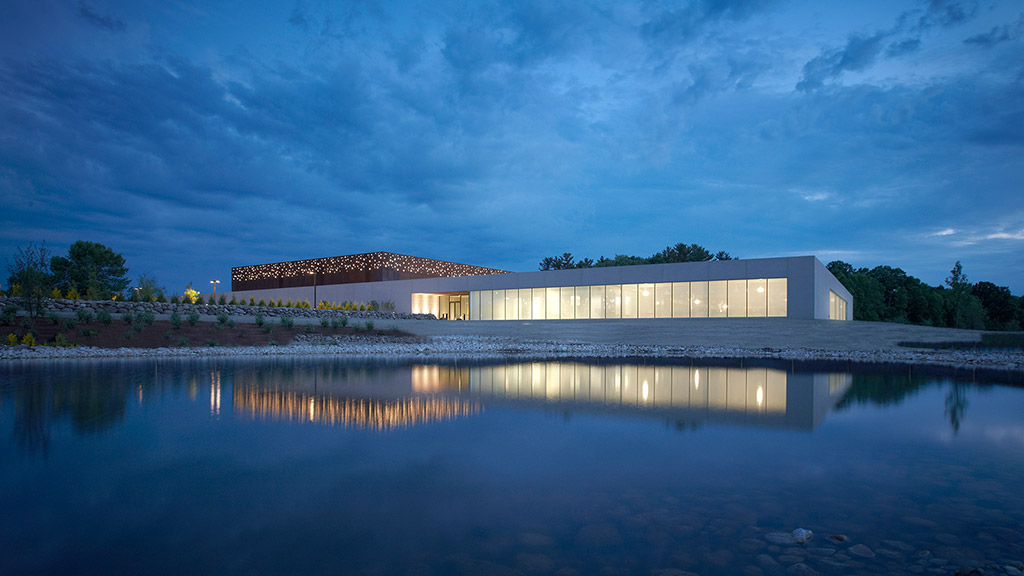 A building with a reflection of the sky in the water.