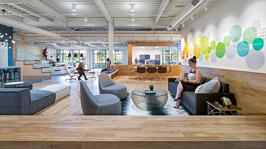 A person sitting on a couch in a large room with balloons.