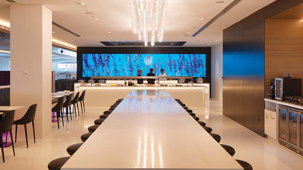 A large room with a large screen and a large table with chairs.