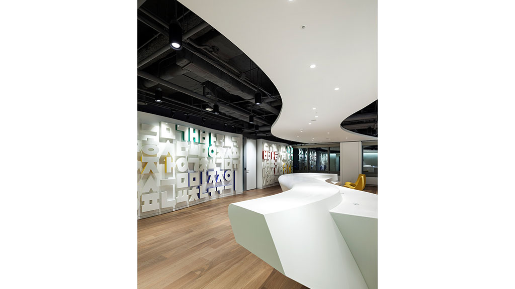 A room with white couches and a wood floor.