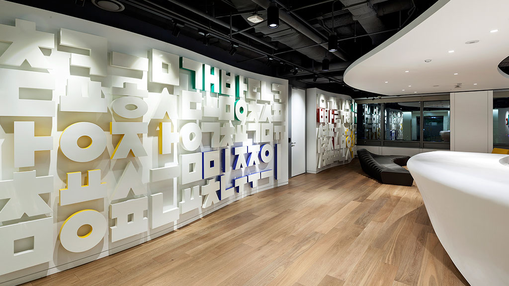 A room with a wall of white circles and a wood floor.