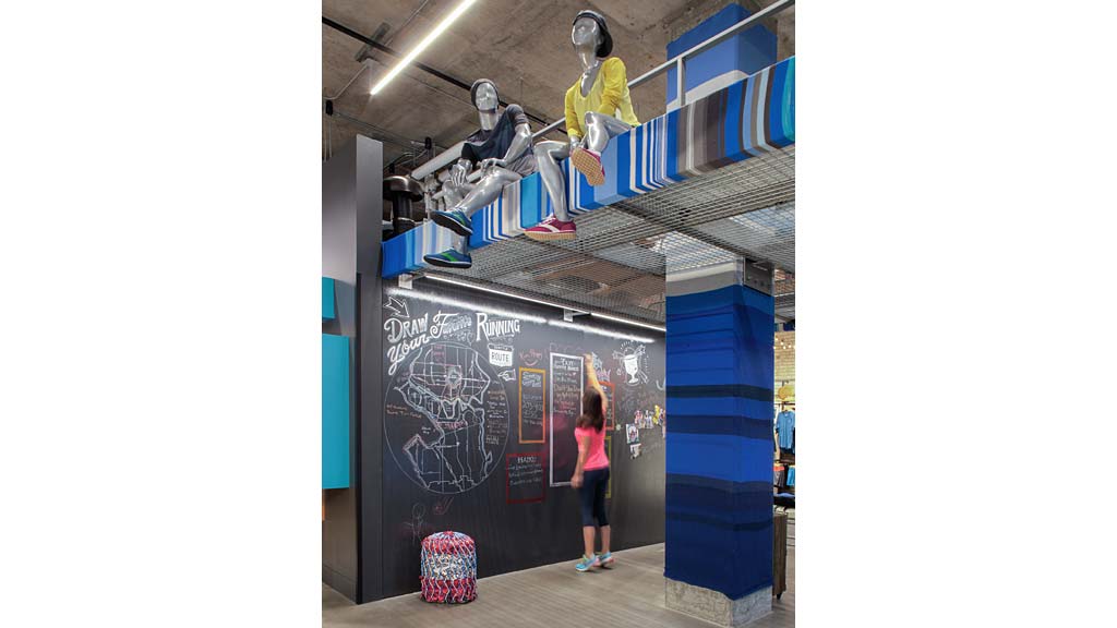 A person standing next to a person in a garment on a blue platform.